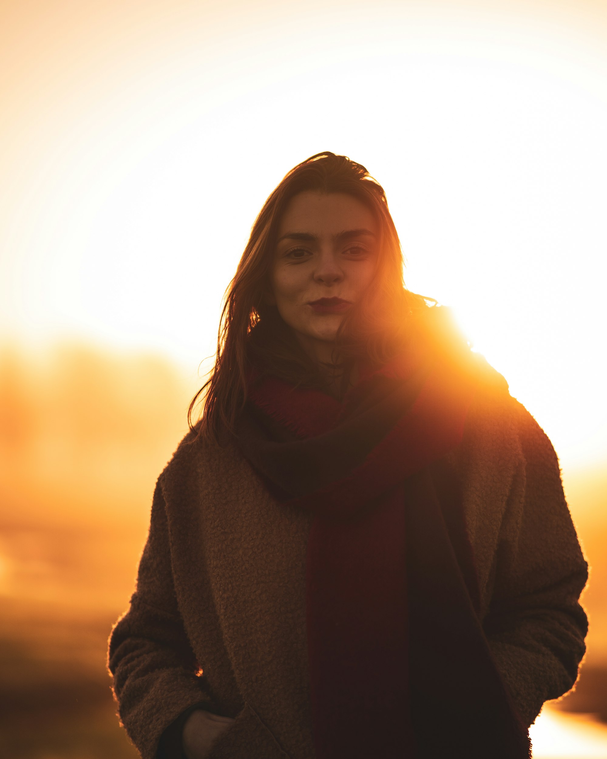 Woman in a dark sweater backlit by golden-hour sun